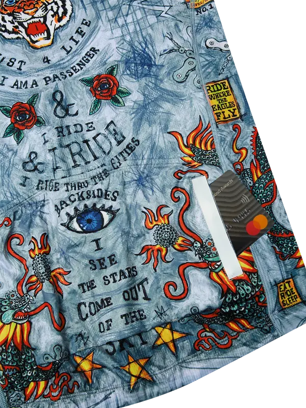 Close-up of a jersey  with tattoo-style designs, text, and symbols on a blue background.